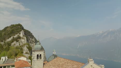 Cinematic-aerial-flyback-over-Tignale-charming-village-and-church-on-Lake-Garda-in-Lombardy,-Italy