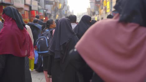 Indian-Muslim-women-wearing-traditional-hijab,-burka-and-fully-covered-walking-through-the-lanes-of-Charminar-Jeweler-market-for-shopping,-slow-motion