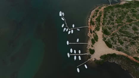 Top-down-aerial-view-of-old-fishing-jetty-in-small-Spanish-island-town