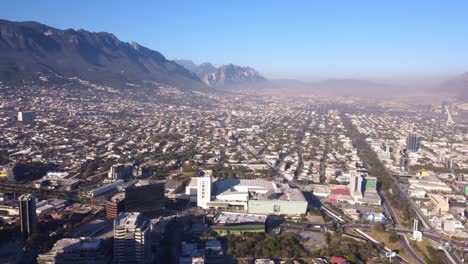 Aerial-view-of-pollution-in-the-city-of-Monterrey,-sunny-day,-spring,-pan-right