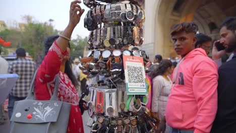 An-Indian-street-vendor-selling-cheap-watches-outside-the-famous-monument-of-Charminar,-UPI-QR-Code-for-contactless,-digital-payment