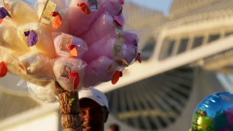 Man-sells-cotton-candy-in-front-of-Museu-do-Amanha,-Tomorrow's-museum,-at-Praca-Maua,-in-Rio-de-Janeiro,-Brazil