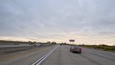 Punto-De-Vista-Desde-El-Capó:-Automóvil-Entrando-En-Los-Suburbios-De-Una-Ciudad-Importante-En-Estados-Unidos,-Timelapse