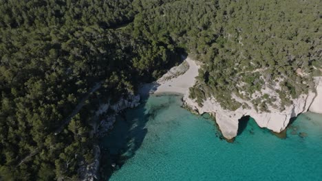 Bosque-En-La-Isla-De-Menorca-Con-Playa-De-Arena-Blanca-Escondida-Y-Aguas-Azules-Perfectamente-Claras-En-España