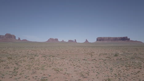 Schneller-Drohnenschuss,-Der-über-Die-Wunderschöne-Landschaft-Des-Monument-Valley-In-Den-USA,-Arizona,-Mit-Einzigartigen-Felsen-Am-Horizont-Fliegt