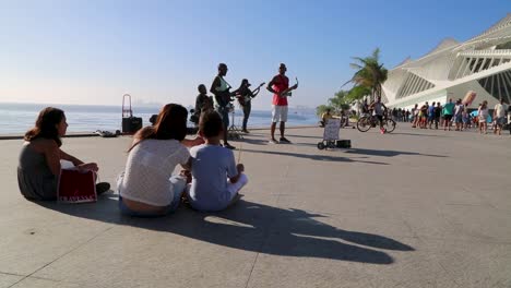 Kinder,-Familie,-Menschen,-Die-Straßenmusikanten-Beobachten,-Und-Menschen,-Die-Bei-Sonnenuntergang-In-Praca-Maua-Im-Zentrum-Von-Rio-De-Janeiro,-Brasilien,-Herumlaufen