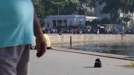 People-sitting-on-a-skate,-relaxing,-on-bikes,-in-front-of-Museu-do-Amanha,-Tomorrow's-museum,-at-Praca-Maua,-in-Rio-de-Janeiro,-Brazil,-on-a-Sunday-afternoon