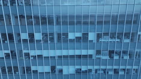 4k-drone-close-up-empty-office-tower-dolly-roll-reveal-partial-windows-covered-as-quadcopter-fly-into-the-mirrored-glass-camera-top-to-a-direct-upwards-mirrored-view-of-condo-office-skyscrapers