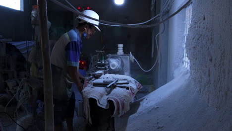 Artist-shaping-piece-of-marble-stone-with-stone-carving-machine-inside-workspace,-Da-Nang-City,-Vietnam