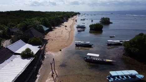 Drone-shot-of-boats-parked-along-the-shore-in-Nusa-Lembongan,-Indonesia