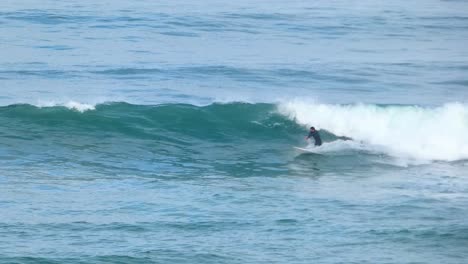 Close-up-slow-motion-shot-of-Handsome-guy-surfing-and-failing-the-span-a-green-wave-in-Guincho,-Europe