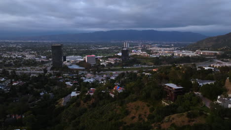 Drone-shot-flying-over-the-Hollywood-hills-toward-University-city,-in-gloomy-LA