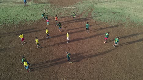 Local-football-teams-play-soccer-game-in-Loitokitok,-Kenya,-aerial