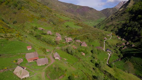 Dolly-out-view-of-straw-cabin-remote-rural-village-on-top-of-valley-in-Asturias,-Spain