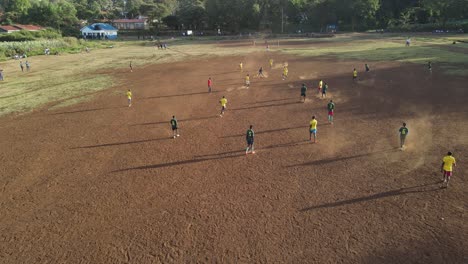 Aerial-view-of-local-football-teams-soccer-game-on-arid-pitch,-Loitokitok,-Kenya