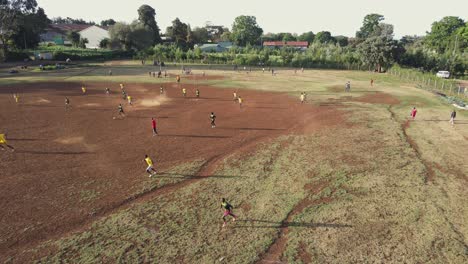 Local-teams-play-football-on-arid-pitch-in-Africa,-aerial-view