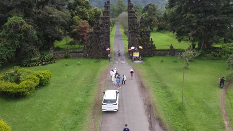 Aerial,-tourists-lined-up-in-a-queue,-couple-posing-for-an-instagram-photo-at-Handara-Gate,-famous-Iconic-Tourist-Attraction-in-Bali-Indonesia