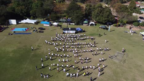 Vídeo-De-Un-Dron-De-Un-Ejercicio-Grupal-En-Un-Campo-En-Bulawayo,-Zimbabwe