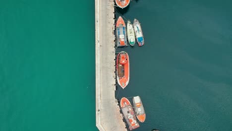 A-drone-flies-over-a-fishing-village,-giving-a-top-down-view-of-the-dock-and-boats
