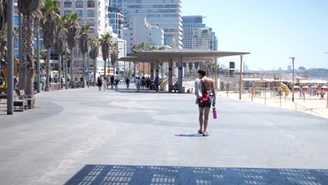 Aufnahme-Eines-Mannes,-Der-Ohne-Hemd-Und-Mit-Einer-Trinkflasche-In-Der-Hand-Durch-Die-Stadt-Tel-Aviv-Läuft