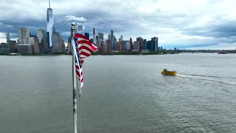 New-Yorker-Wassertaxi-Auf-Dem-Hudson-River-Mit-Der-Skyline-Von-Lower-Manhattan-Und-Der-US-Flagge