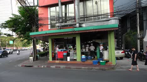 Point-of-view-of-a-group-of-workers-busy-preparing-food-and-washing-dishes-in-the-local-restaurants-at-Sala-Daeng,-Soi-1,-Bangkok,-Thailand