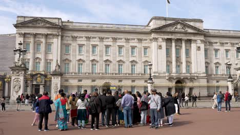 Visita-Turística-En-Grupo-Con-Guía-Turístico-Fuera-Del-Palacio-De-Buckingham.