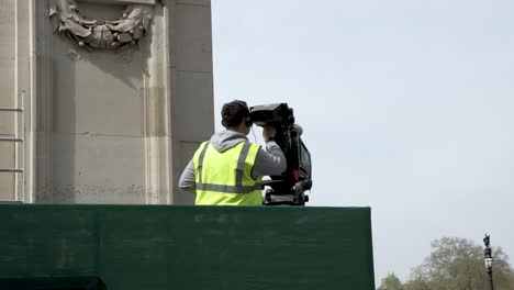 4-May-2023---Cameraman-Wearing-Hi-Vis-Preparing-Live-TV-Broadcast-Camera-For-King-Charles-Coronation-At-The-Mall,-Buckingham-Palace