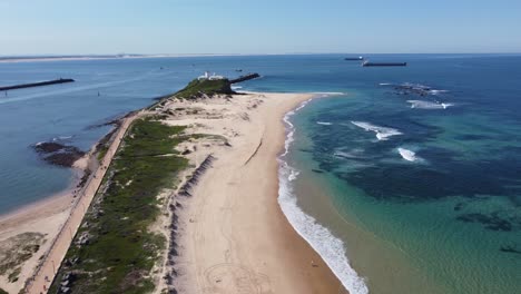Aerial-drone-shot-of-beautiful-Nobbys-Beach-surfing-and-sand-clear-water-harbour-travel-tourism-Newcastle-NSW-Australia-4K