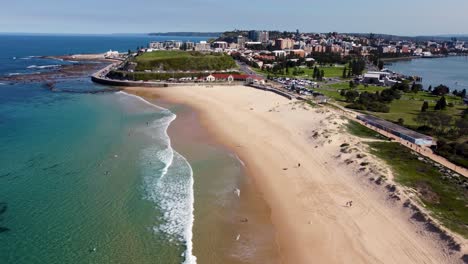 Luftdrohnenaufnahme-Von-Nobbys-Beach,-Newcastle,-Pazifischer-Ozean,-Schöner-Tag,-Sandstrand,-Reisetourismus,-Gebäude,-Stadt,-CBD,-NSW,-Australien,-4K