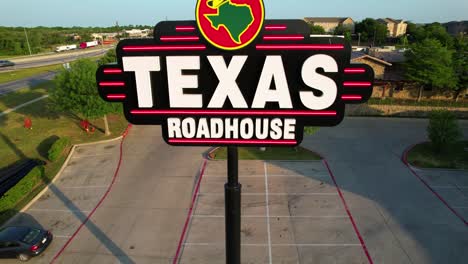 Aerial-footage-of-the-Texas-Roadhouse-sign-in-Denton-Texas-located-at-2817-S-Interstate-35,-Denton,-TX-76205