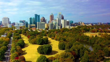 Aerial-drone-shot-of-the-downtown-Atlanta,-Georgia-skyline-slowly-descending-over-Piedmont-Park