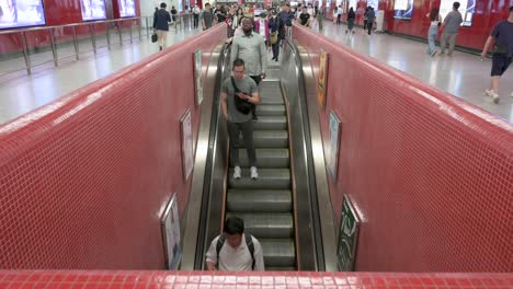 Asian-commuters-ride-on-an-automatic-moving-escalator-at-a-subway-station