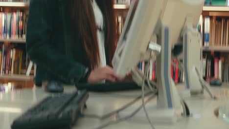Female-Asian-student-working-at-a-computer-station-in-the-library
