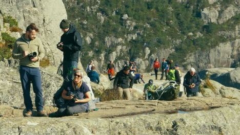 Excited-tourists-gathered-on-the-rocky-peak-of-Preikestolen-Pulpit-Rock-on-a-sunny-day