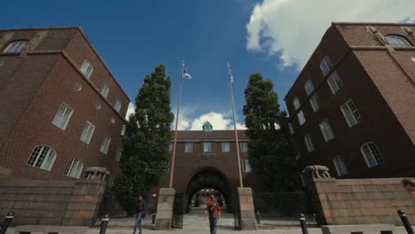 Vista-De-ángulo-Bajo-De-La-Entrada-Arqueada-A-La-Késima-Universidad-Mientras-Los-Estudiantes-Entran-Y-Salen-Del-Campus