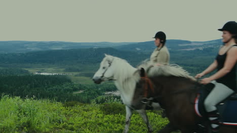 A-couple-of-women-riding-horses-on-a-high-mountain-pass-in-front-of-the-camera