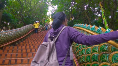 Eine-Asiatische-Frau-Steigt-Die-Treppe-Hinauf,-Die-Zum-Buddhistischen-Tempel-Wat-Phra-That-Doi-Suthep-Führt