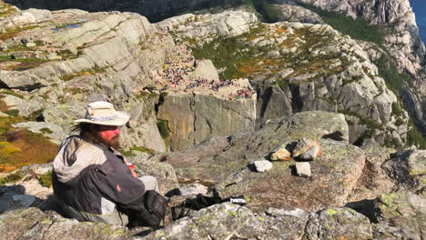 Hipster-cowboy-relaxing-on-the-rocky-stone-edge-of-Preikestolen-Pulpit-rock-in-Norway