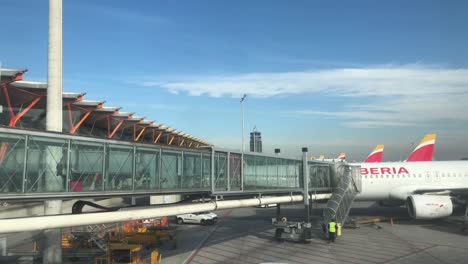 Panoramic-shot-of-a-jetbridge-in-an-airport-with-people-boarding-the-plane