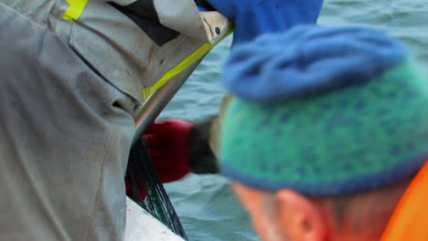 Two-fishermen-working-together-to-pull-empty-nets-from-the-cold-nordic-sea