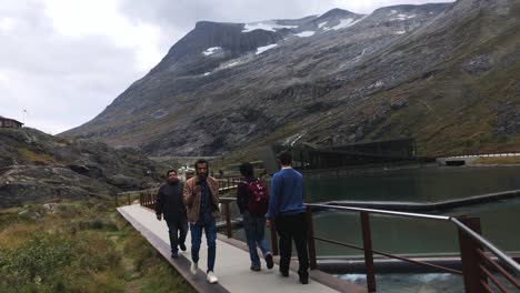 Turistas-Que-Visitan-Trollstigen-Y-Caminan-Por-La-Moderna-Pista-Sobre-El-Agua.