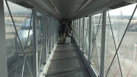 View-inside-a-jet-bridge-of-people-boarding-an-airplane