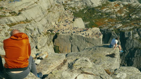 Pareja-De-Turistas-Recordando-Recuerdos-En-El-Acantilado-Rocoso-Del-Púlpito-Preikestolen-En-Noruega