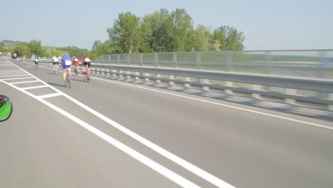 Cyclists-Race-Along-Open-Road-In-Summer