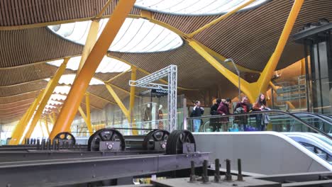 Panoramaaufnahme-Von-Menschen,-Die-Eine-Rolltreppe-In-Einem-Terminal-Des-Flughafens-Madrid-Nehmen