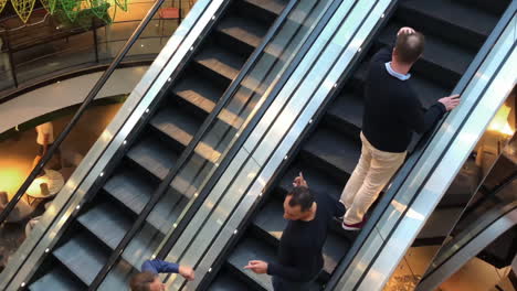 Group-of-friends-on-a-moving-escalator-catching-up-in-a-shopping-mall-on-the-weekend