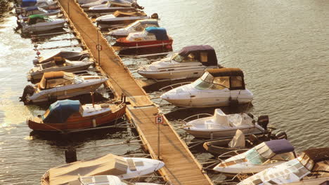 Barcos-Amarrados-En-Un-Muelle-Flotante-En-La-Puesta-De-Sol-De-Estocolmo-Con-Tráfico-En-Segundo-Plano.