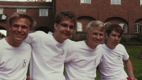 Vier-Freunde-In-Passenden-Weißen-Hemden-Sitzen-Lächelnd-Und-Lachend-Dicht-Beieinander