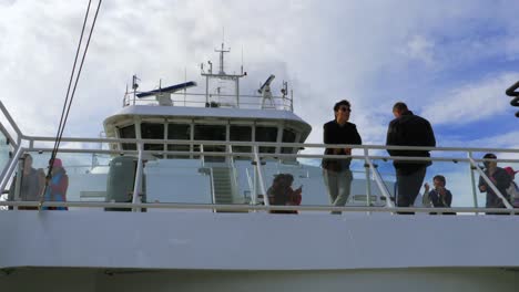 Passengers-stand-outside-enjoying-the-scenery-and-taking-pictures-during-their-ferry-ride